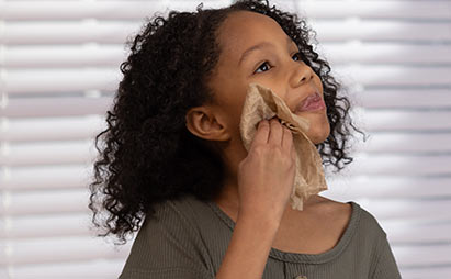 young girl washing her face with a bravo towel